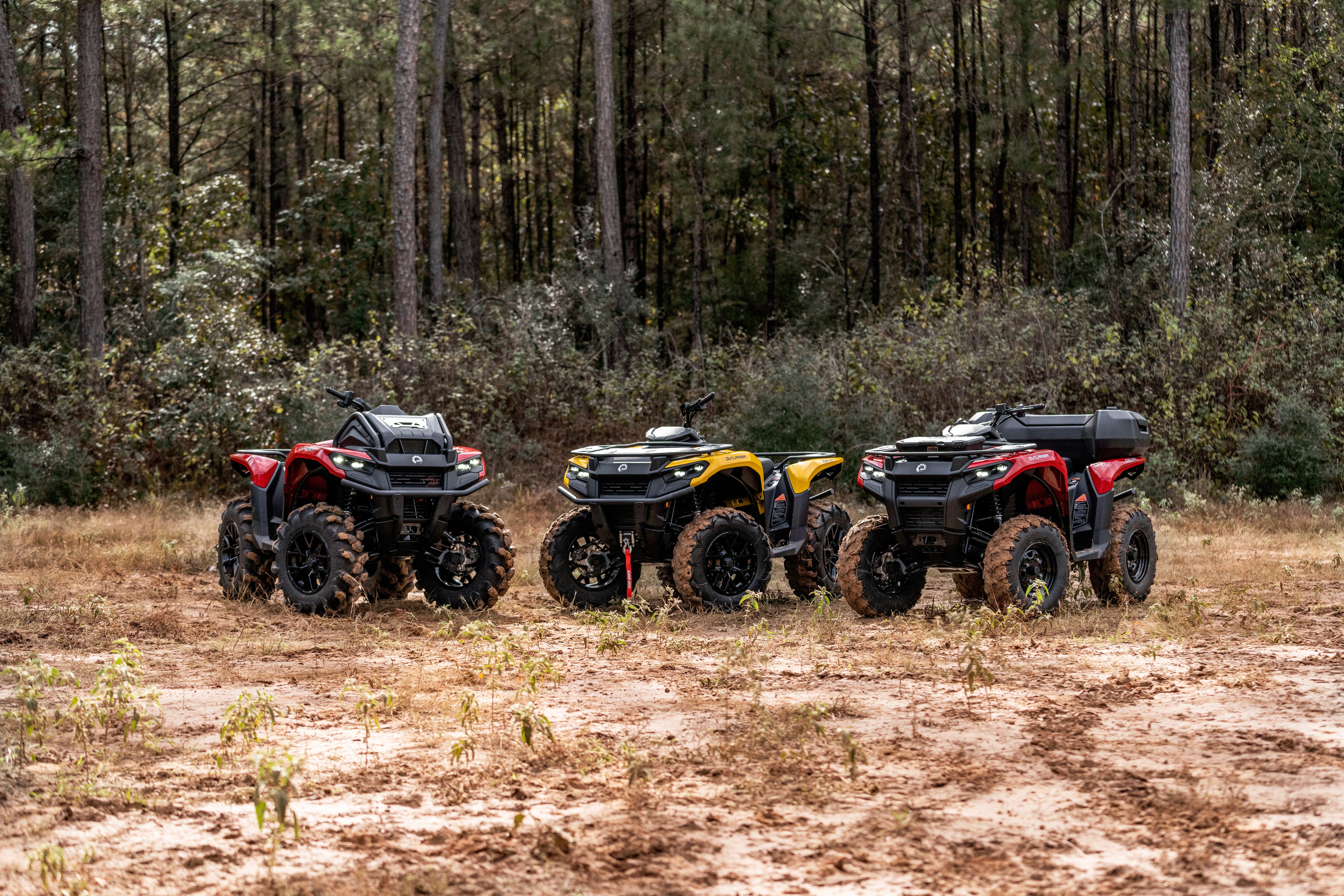 Family shot of three Can-Am Outlander in front of the forest